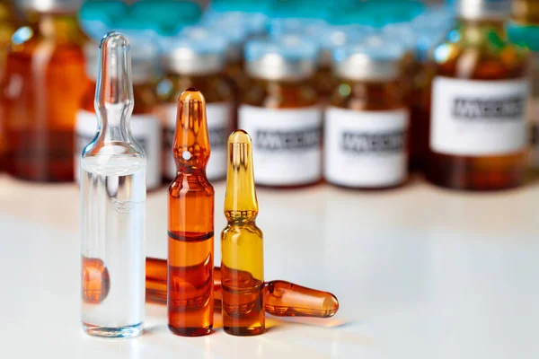 Montón de frascos médicos de vidrio con medicamentos en la mesa de laboratorio — Foto de Stock
