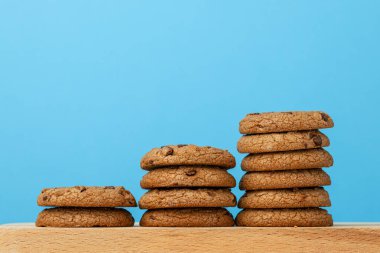 Mavi arka planda çikolata parçacıklı kurabiye yığını