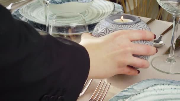 Großaufnahme einer Frau, die Kerze auf den Tisch stellt — Stockvideo