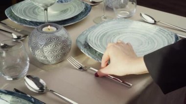 Masayı hazırlayan kadına yakın durun. Garson ya da ev hanımı yemek masasına çatal bıçak koyuyor.