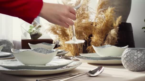 Κοντινό πλάνο της γυναίκας που στρώνει τραπέζι. Νοικοκυρά ή σερβιτόρα χέρια βάζοντας πιάτα στο τραπέζι — Αρχείο Βίντεο