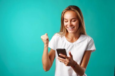 Genç sarışın sıradan bir kız akıllı telefonunu kullanıyor..