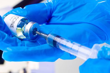 Covid-19 aşı şişesi. İçinde şırınga var. Aşıyı alıyor.