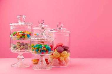 Pembe arka planda şekerli cam kaplar