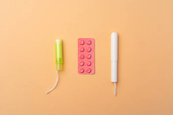 Damskie tampony medyczne i tabletki przeciwbólowe widok z góry — Zdjęcie stockowe