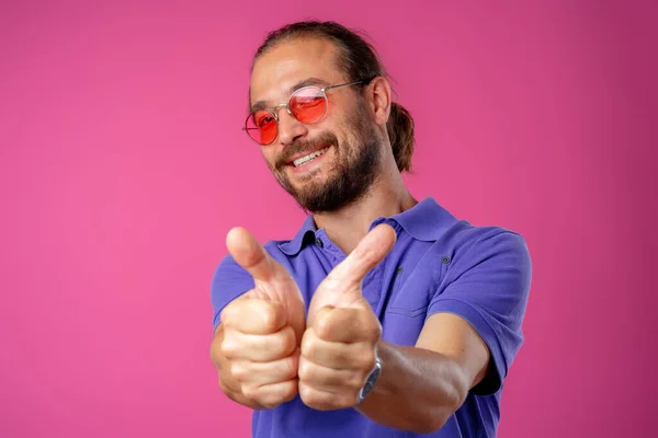 Homem de cabelos longos em óculos mostrando polegares para cima gesto — Fotografia de Stock