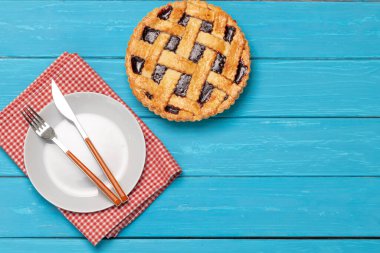 Mavi ahşap arka planda meyveli turta.