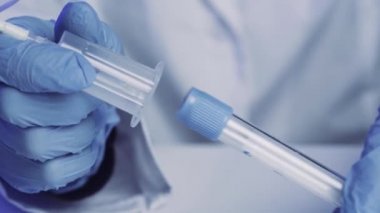Hemşirenin kan toplama sistemine tüpü doldurduğu yakın plan.