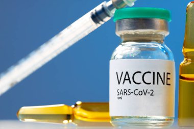 Sars-cov-2 aşı şişesi ve şırınga beyaz masa üzerinde