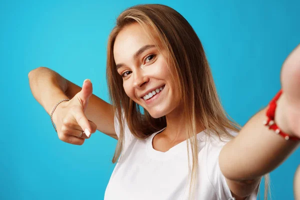 Positiv ung blond kvinna tittar på kameran och pekar på dig — Stockfoto