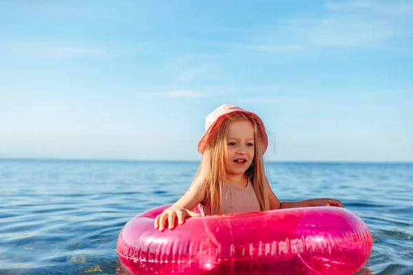 Jeune fille en panama rose nageant dans la mer avec cercle — Photo