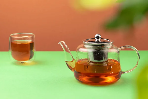 Стеклянный чайник и чашка с черным чаем — стоковое фото