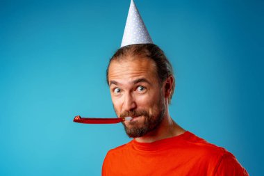 Parti konisindeki uzun saçlı komik adam.