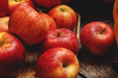 Tahta masaya kırmızı elma yığını. Yaklaş.