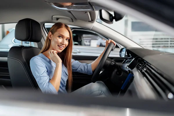 Щаслива жінка новий власник автомобіля сидить на сидінні водія — стокове фото