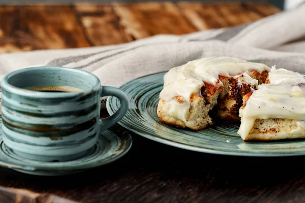 Pain de cinnabon glacé dans une assiette verte sur une table en bois — Photo