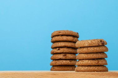 Mavi arka planda çikolata parçacıklı kurabiye yığını