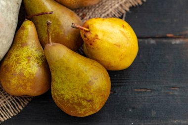 Siyah ahşap masada dört yeşil armut.