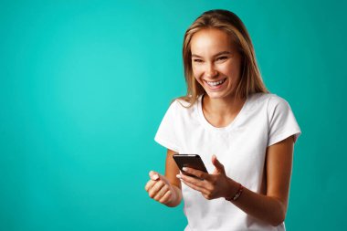 Genç sarışın sıradan bir kız akıllı telefonunu kullanıyor..