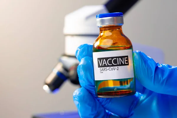 Covid-19 백신을 들고 있는 파란 장갑을 낀 의사의 손 — 스톡 사진