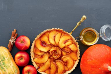 Elmalı turta ve tahta masada kırmızı elmalar.