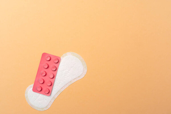 Женский медицинский блокнот и обезболивающие таблетки