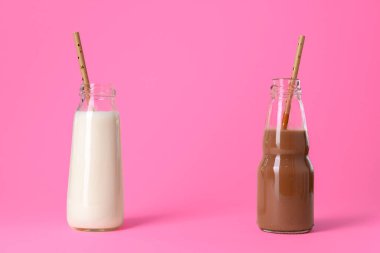 Pembe arka planda iki bardak süt ya da milkshake.