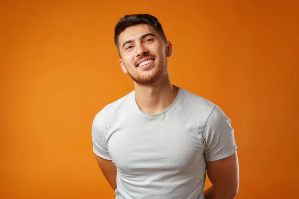 Jovem homem positivo em branco camisa casual de pé com sorriso feliz — Fotografia de Stock