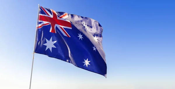 Vlag van Australië zwaaiend tegen blauwe lucht — Stockfoto
