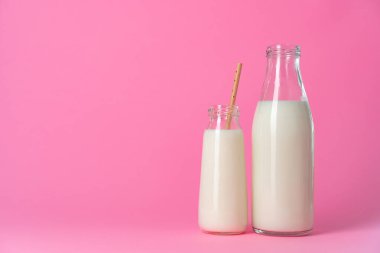 Pembe arka planda iki bardak süt ya da milkshake.