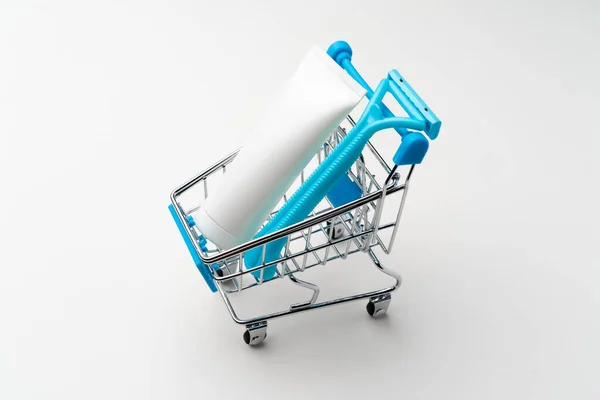 Female disposable shaver in toy shopping cart on white background — Stock Photo, Image