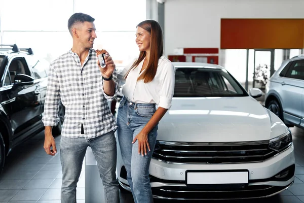 Mladý šťastný pár právě koupil nové auto v prodejně — Stock fotografie