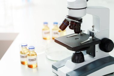 Bilim laboratuarında aşı şişeleri ve mikroskop.