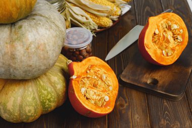 Koyu ahşap masada ikiye bölünmüş balkabağı.