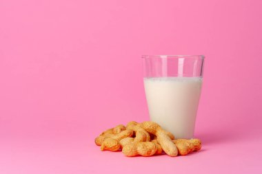 Sütsüz vejetaryen sütü. Pembe arka planda fındıktan yapılmış.