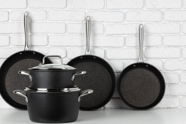 Masada beyaz tuğla duvara karşı yemek takımı