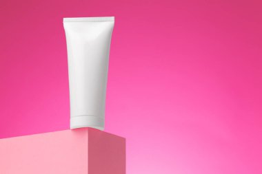 Pembe arka planda boş beyaz kozmetik kabı