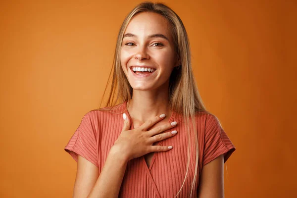 Fridfull ung blond kvinna som håller händerna på bröstet. — Stockfoto