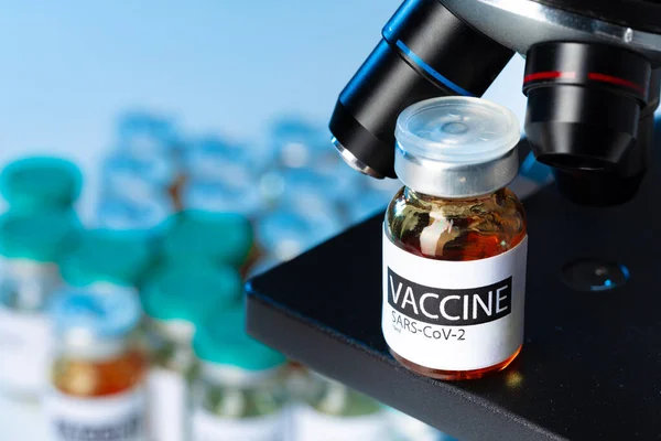 Covid-19 백신 의 Vial 옆에 현미경 — 스톡 사진