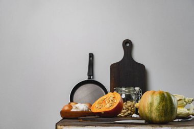 Gri duvara karşı mutfak masasında balkabakları