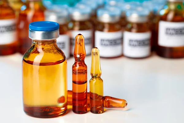 Montón de frascos médicos de vidrio con medicamentos en la mesa de laboratorio — Foto de Stock