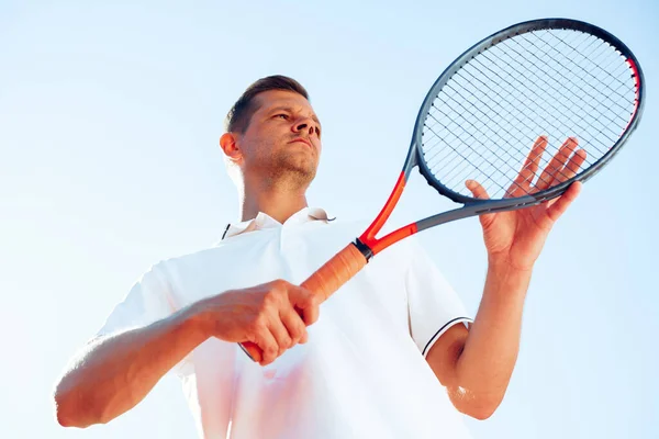 Jovem jogador de tênis verifica sua raquete para iniciar um jogo — Fotografia de Stock