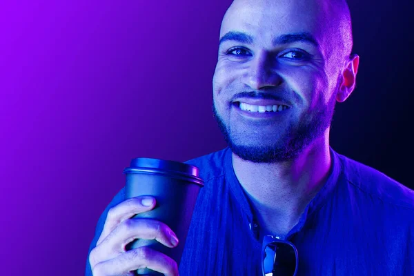 Afro americano homem segurando xícara de café em luz de néon — Fotografia de Stock