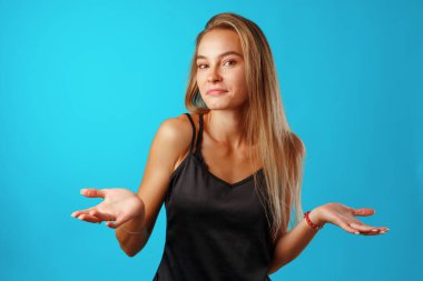 Şaşırmış genç bir kadın bilmediğine dair işaretler yapıyor..