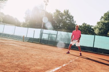 Açık havada tenis oynayan orta yaşlı bir adam dosyalanmış.