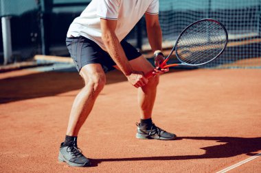 Tenis oyuncusu tenis kortunda hazır bekliyor.