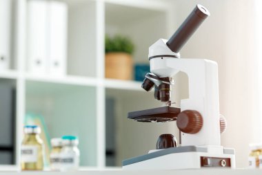 Laboratuvarda cam eşyalar ve mikroskop var.