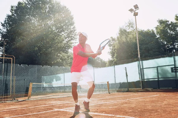 Mann mittleren Alters spielt Tennis im Freien — Stockfoto