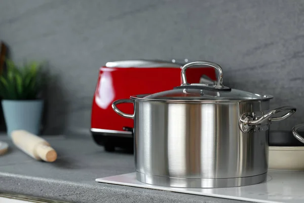 台所の誘導ストーブの上の金属鍋の静物写真 — ストック写真