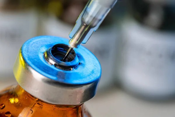 Бутылка вакцины со шприцем, забирающая вакцину из нее. — стоковое фото